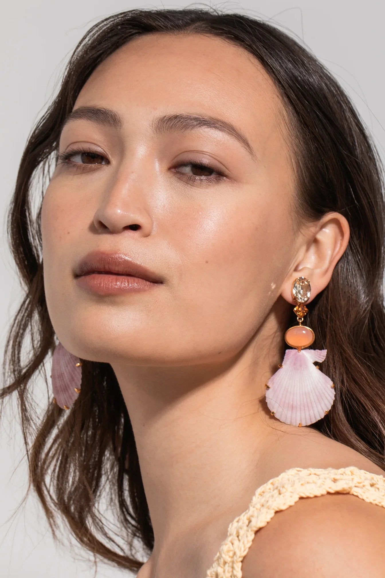 Model wearing Jennifer Behr Adrielle Earrings with natural purple scallop shell drop earrings.