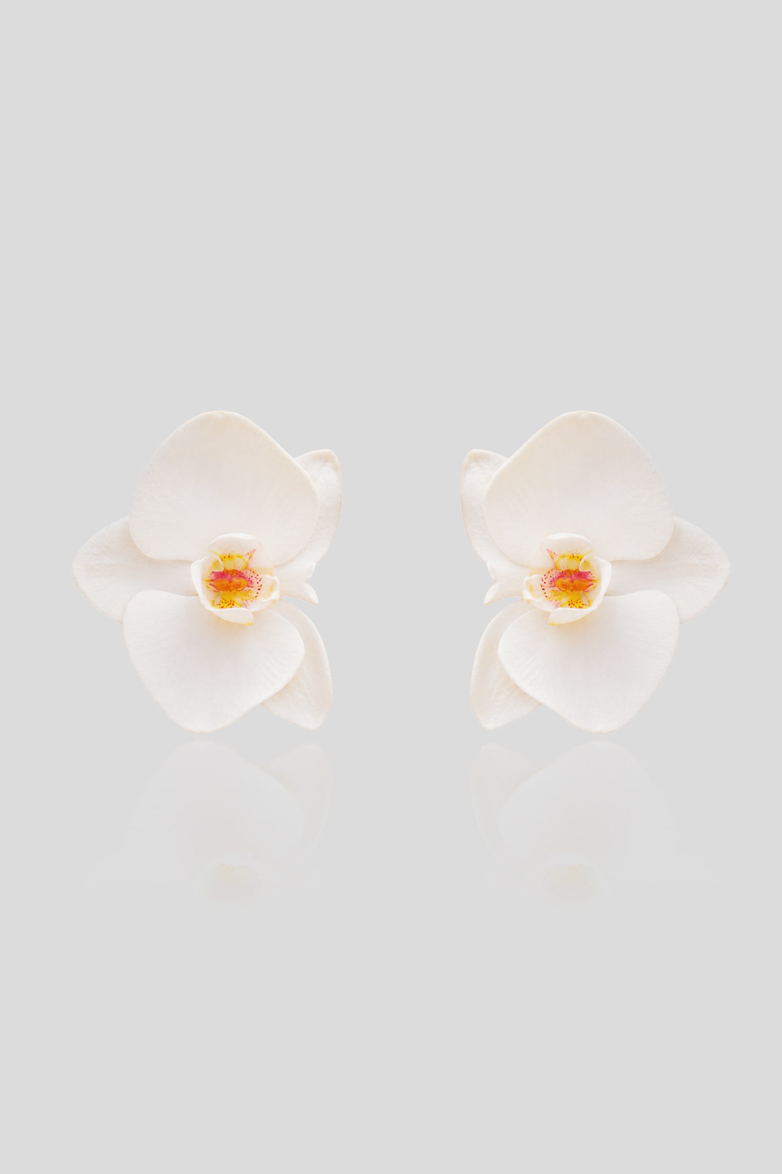 kenza klay White orchid flower statement earrings with delicate sculpted petals and soft yellow-pink centers