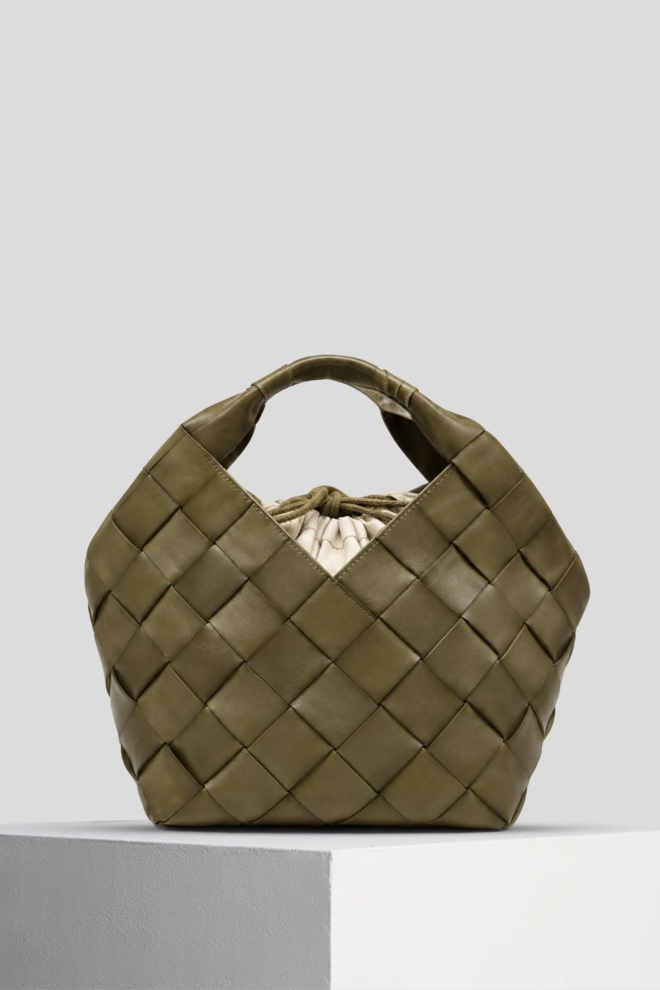 The Botteghe Khaki bucket bag with wide diagonal leather strips and integrated handles.