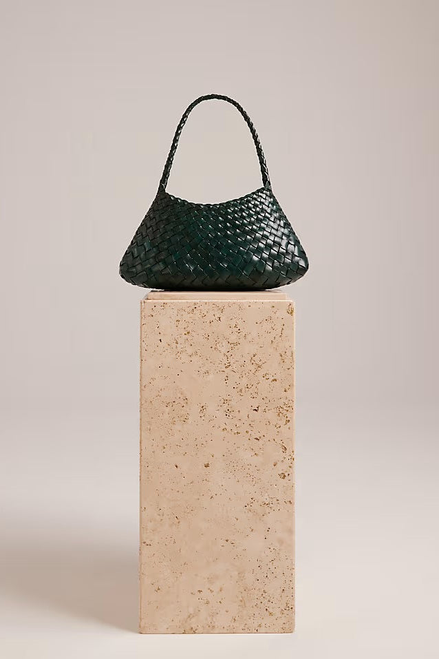 Forest-green Rosalia Shoulder Bag displayed on a stone pedestal.