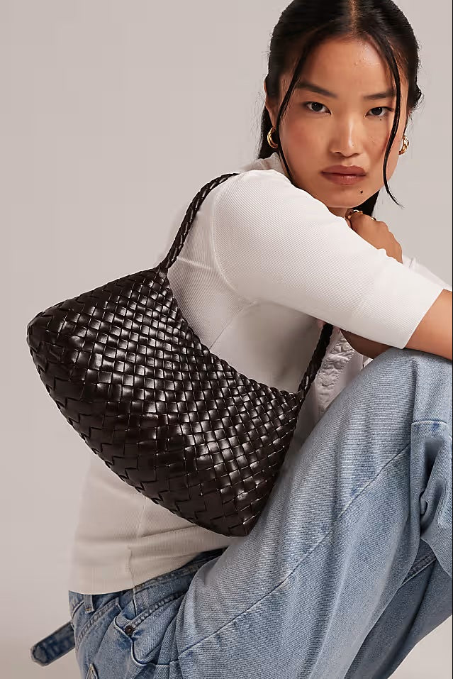 Model carrying the dark-brown Rosalia woven leather bag over her shoulder.
