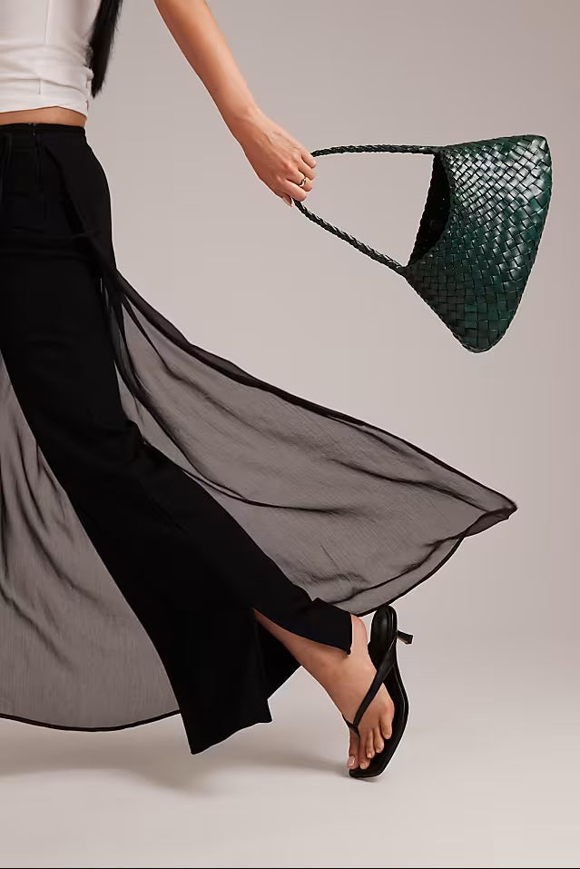 Model holding the forest-green Rosalia Shoulder Bag by its braided strap.
