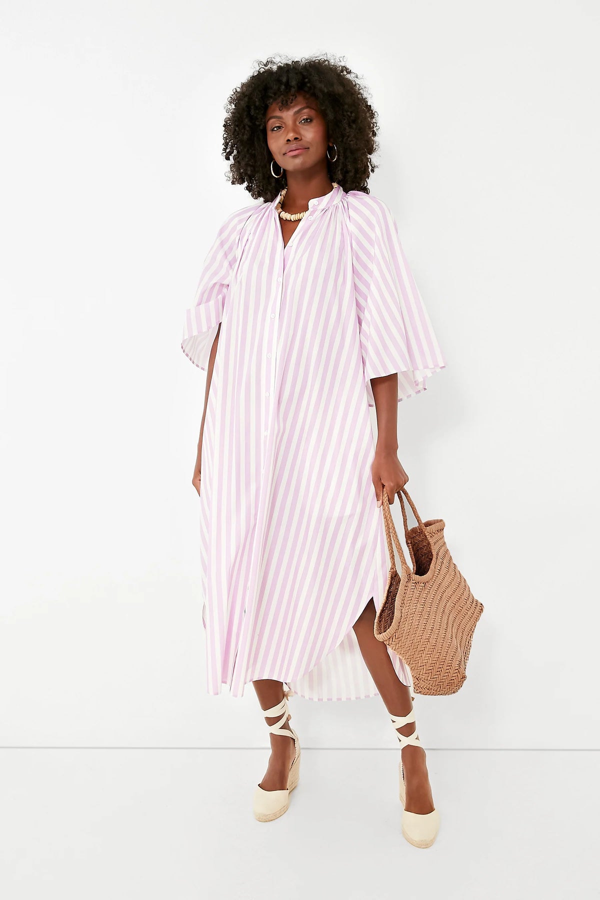 Model styling the Nantucket Large Tote in natural with a striped midi dress.