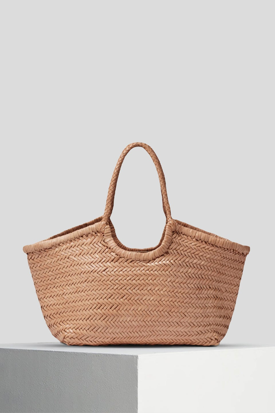 Nantucket Large Tote in natural handwoven leather displayed on a white pedestal.