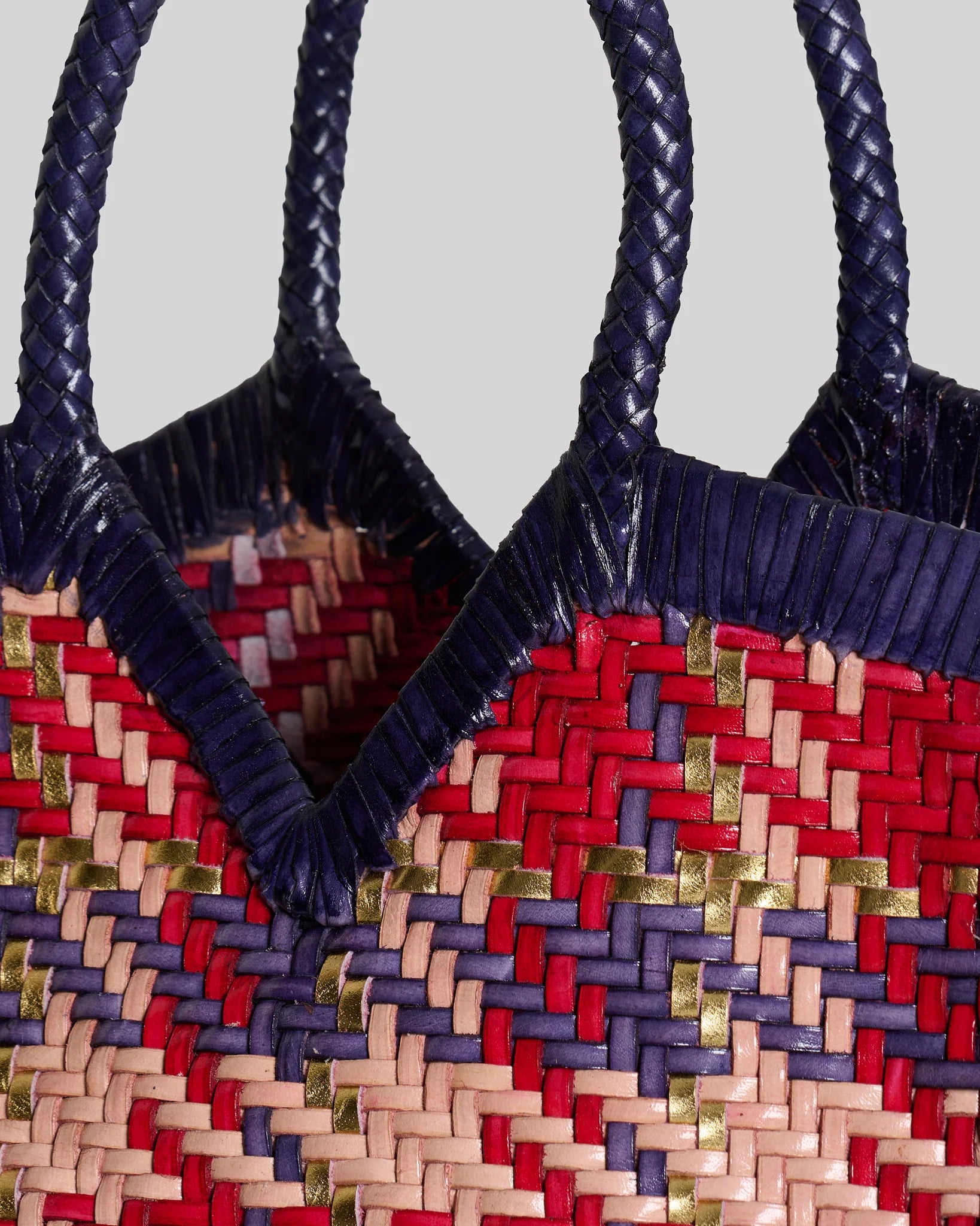 Close-up of the Vipera Monet Madras tote featuring handwoven leather with braided handle detailing.