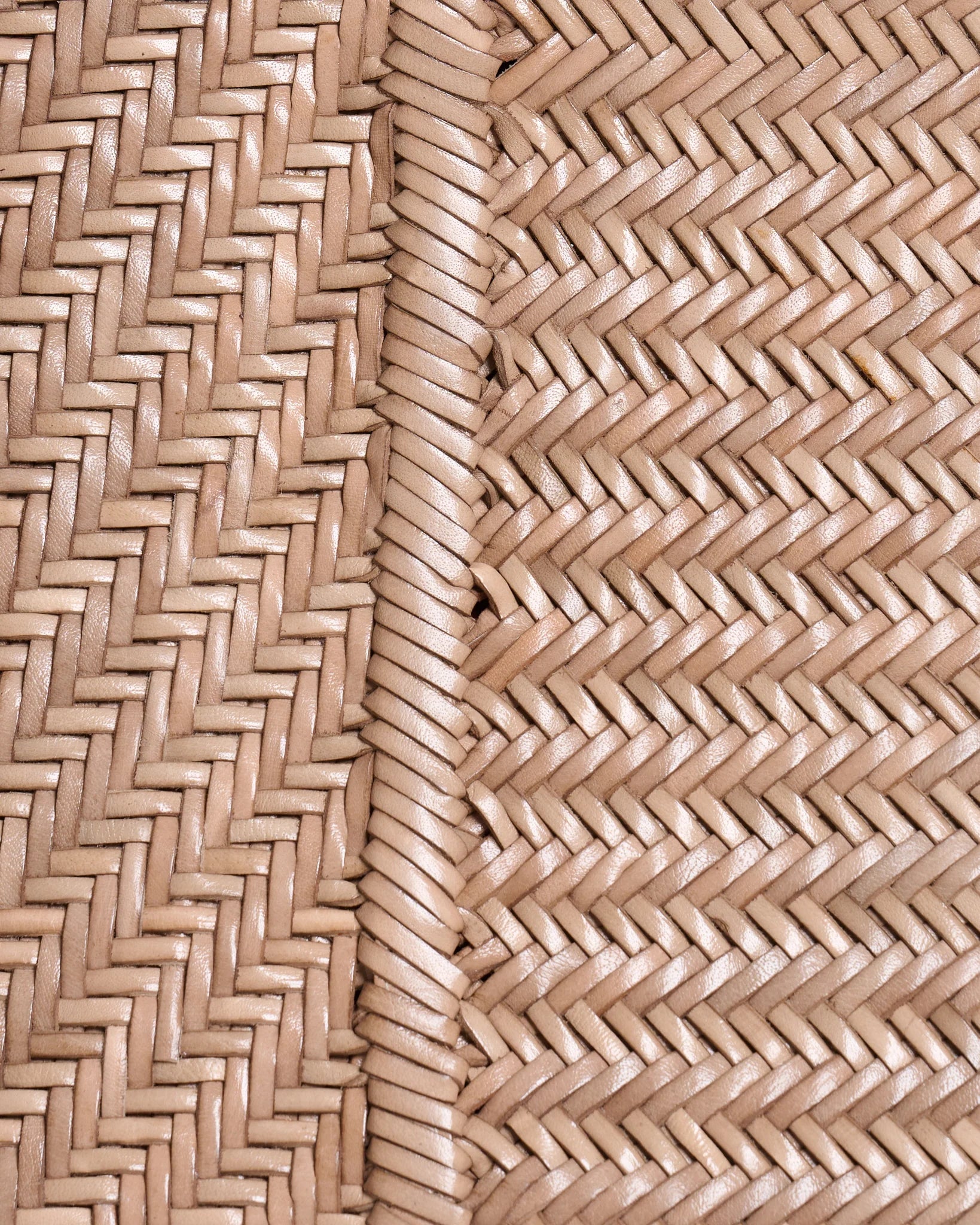 Close-up of the handwoven taupe leather craftsmanship and braided detailing on the Vipera Pillow clutch.