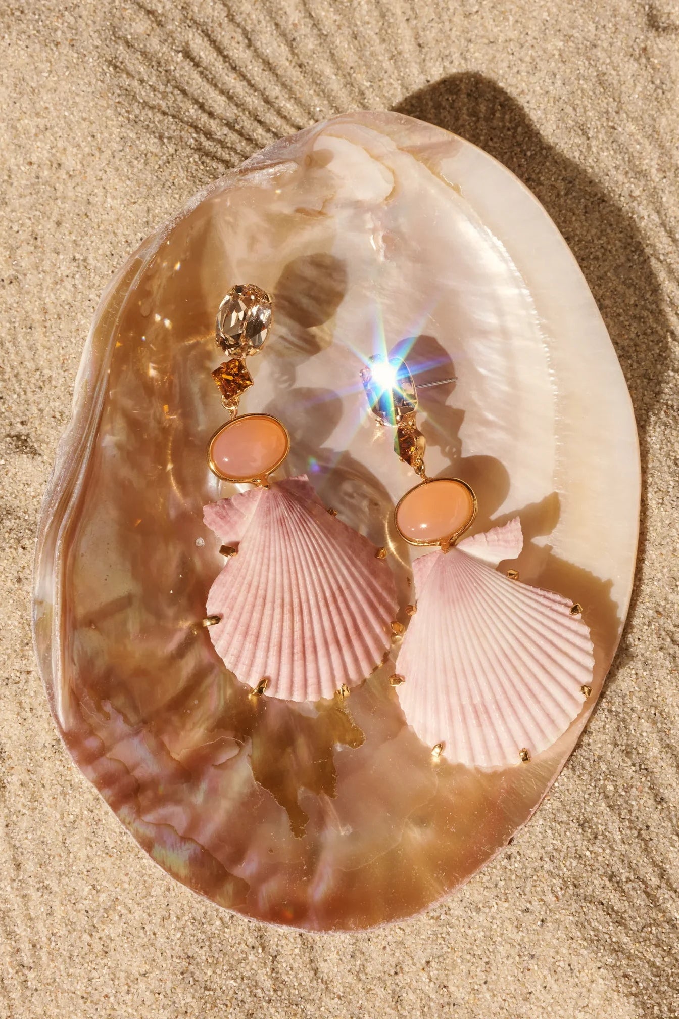 Jennifer Behr Adrielle Earrings styled on a natural mother-of-pearl shell with soft coastal inspiration.