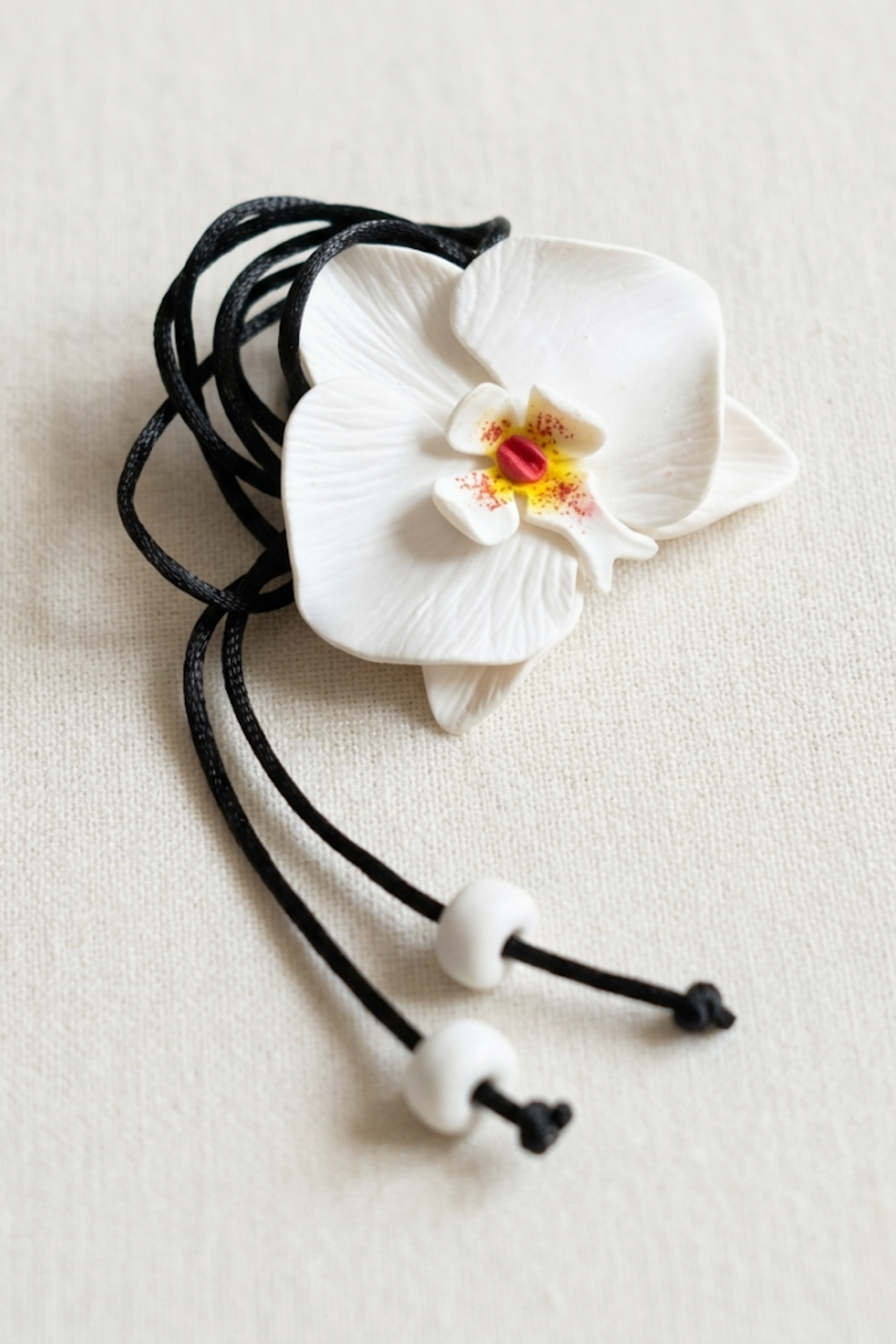 Model wearing the Bianca Orchid Necklace, a handcrafted white orchid necklace with a delicate floral design and lightweight silhouette.
