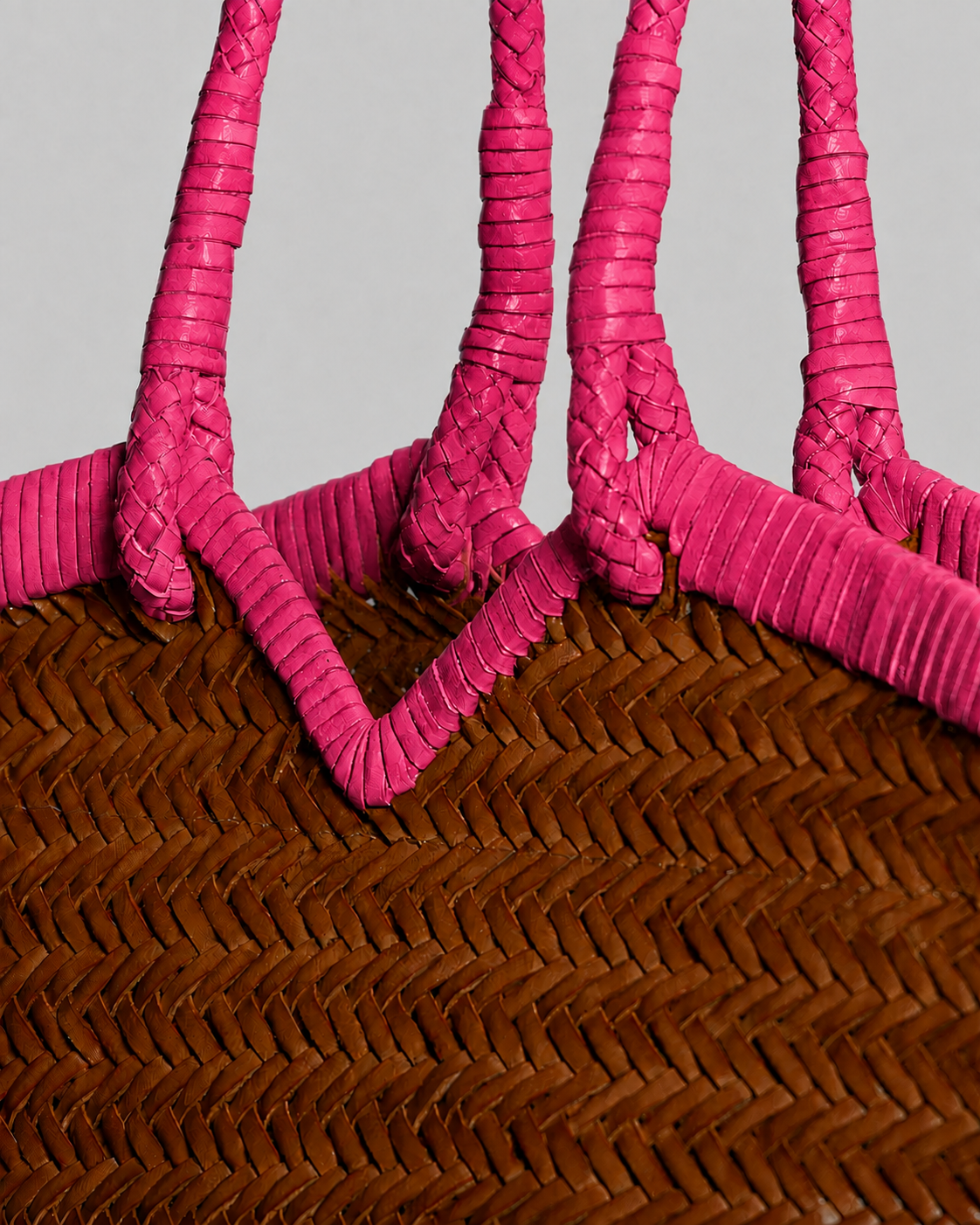 Close-up of the Vipera Crudelia Bicolor Cognac–Pink highlighting the intricate handwoven cognac leather craftsmanship and bright lipstick-pink leather trim.