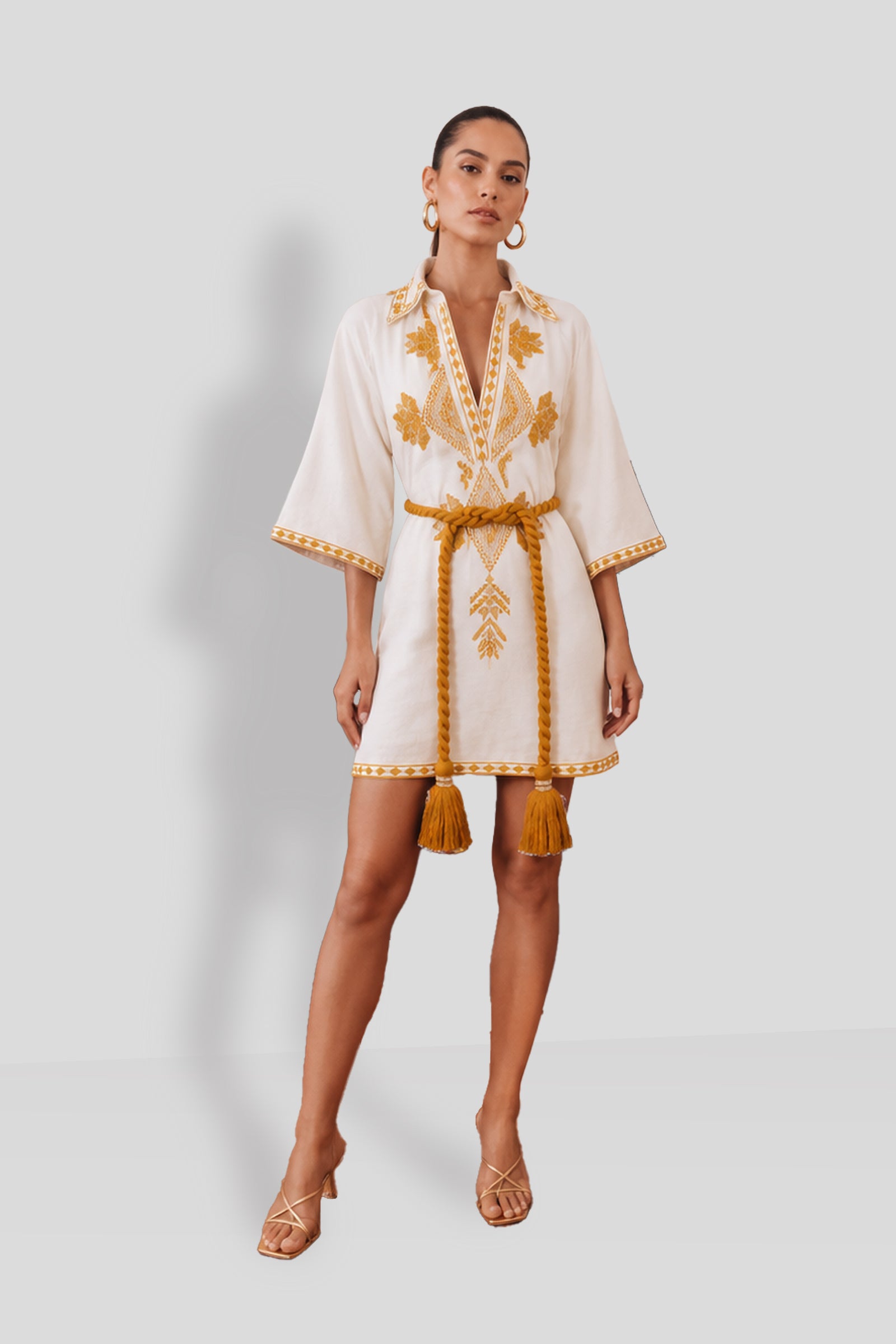 Natacha & Vanessa Dalia Mini Dress in ecru featuring ochre and gold geometric embroidery, a V-neckline, 3/4 sleeves, and a detachable twisted rope belt.