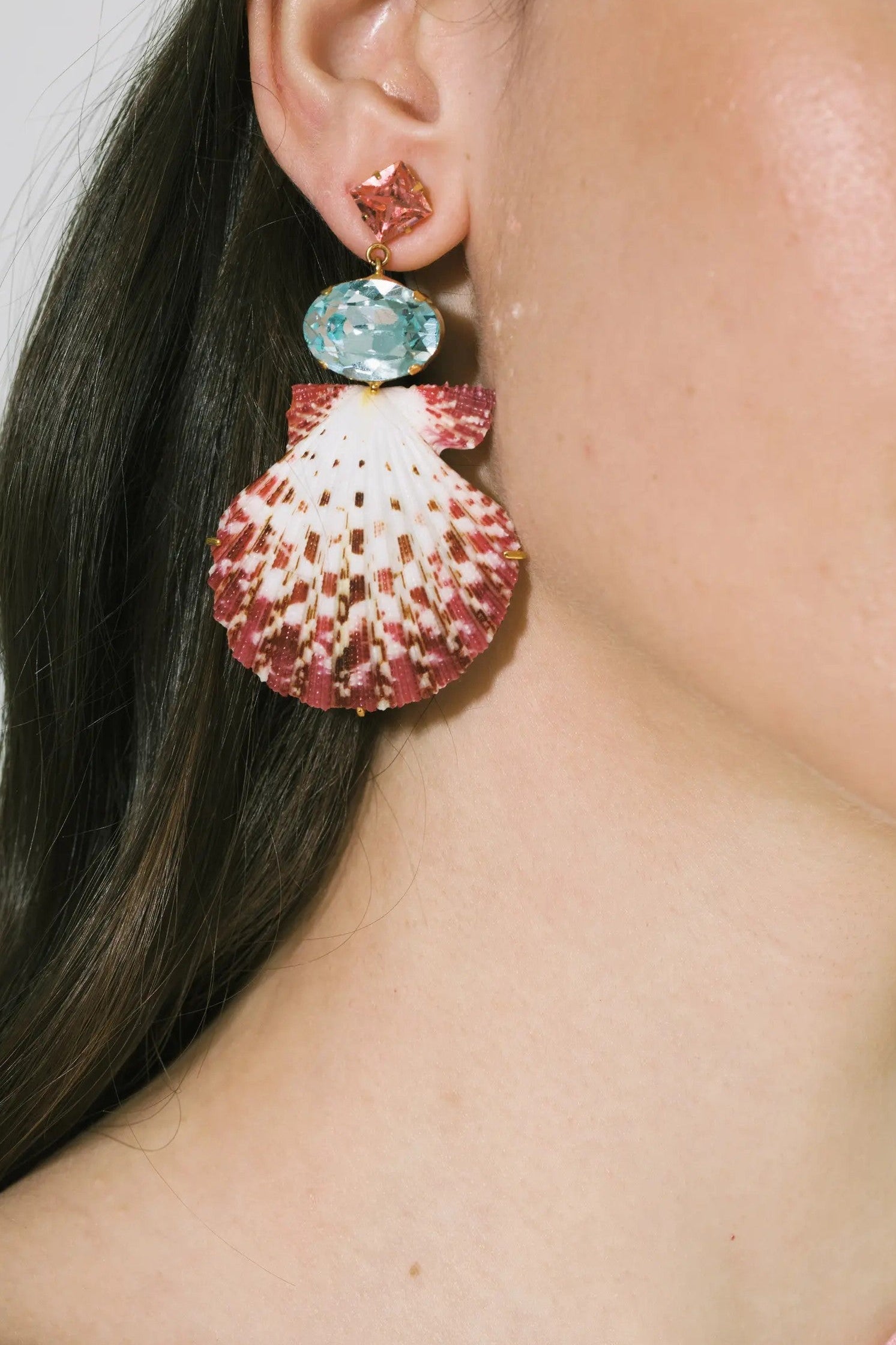 Model wearing Jennifer Behr Aegean Shell Drop Earrings featuring pink and aqua crystals with sculptural shell drops.