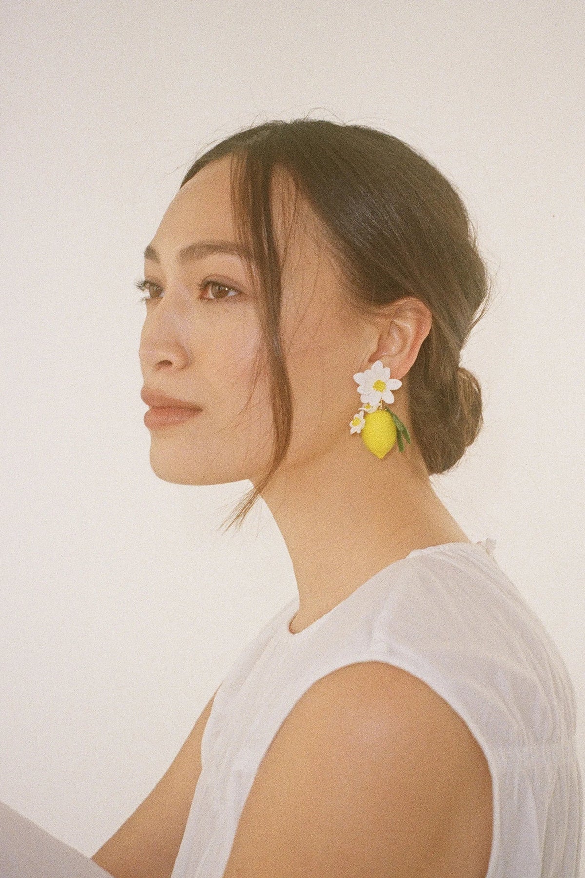 Model wearing Jennifer Behr Limoncello Earrings highlighting the statement drop silhouette and handcrafted botanical design