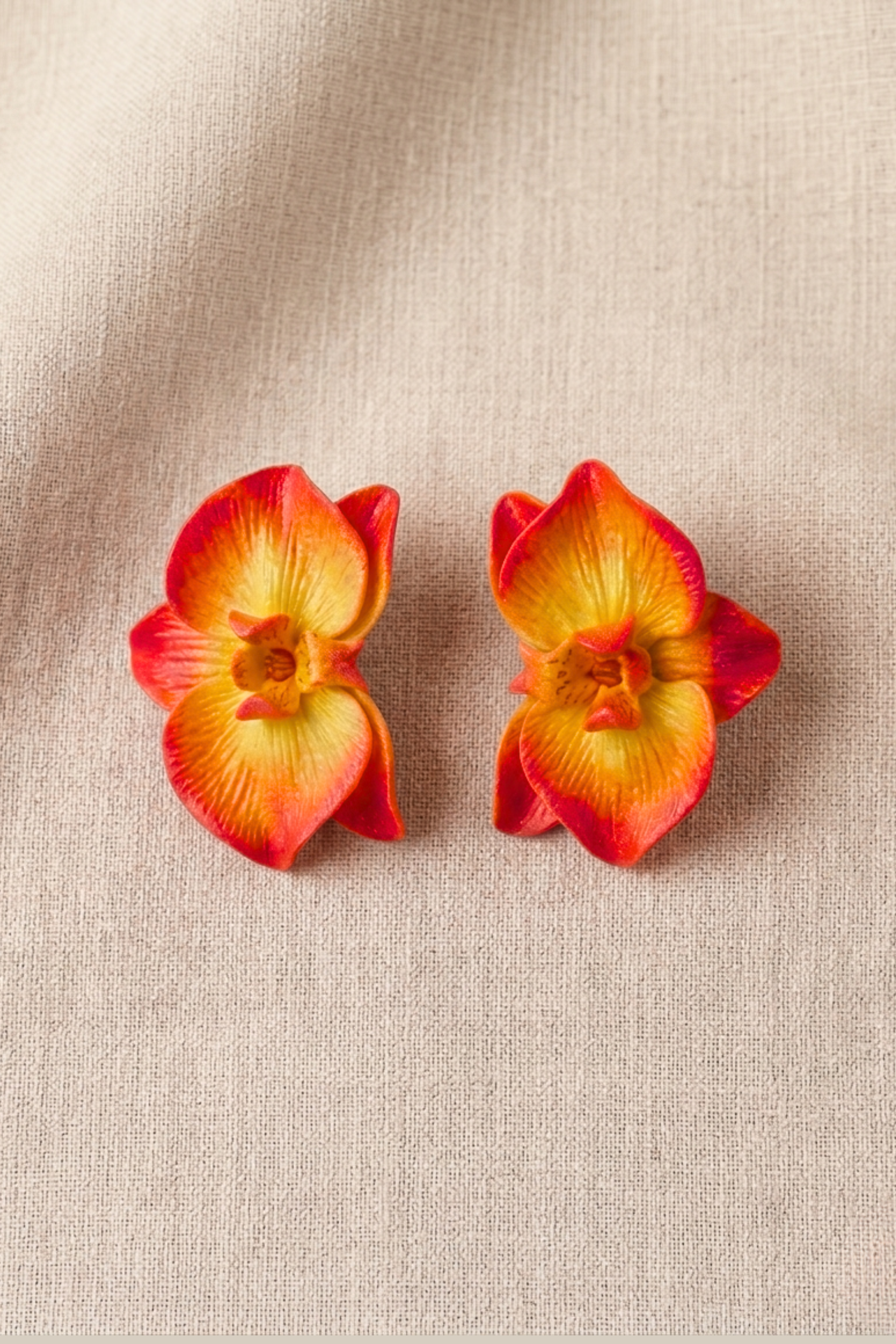 Handcrafted Sunset Orchid Earrings in polymer clay, featuring realistic orchid flowers with sunset-inspired yellow, orange, and red petals.