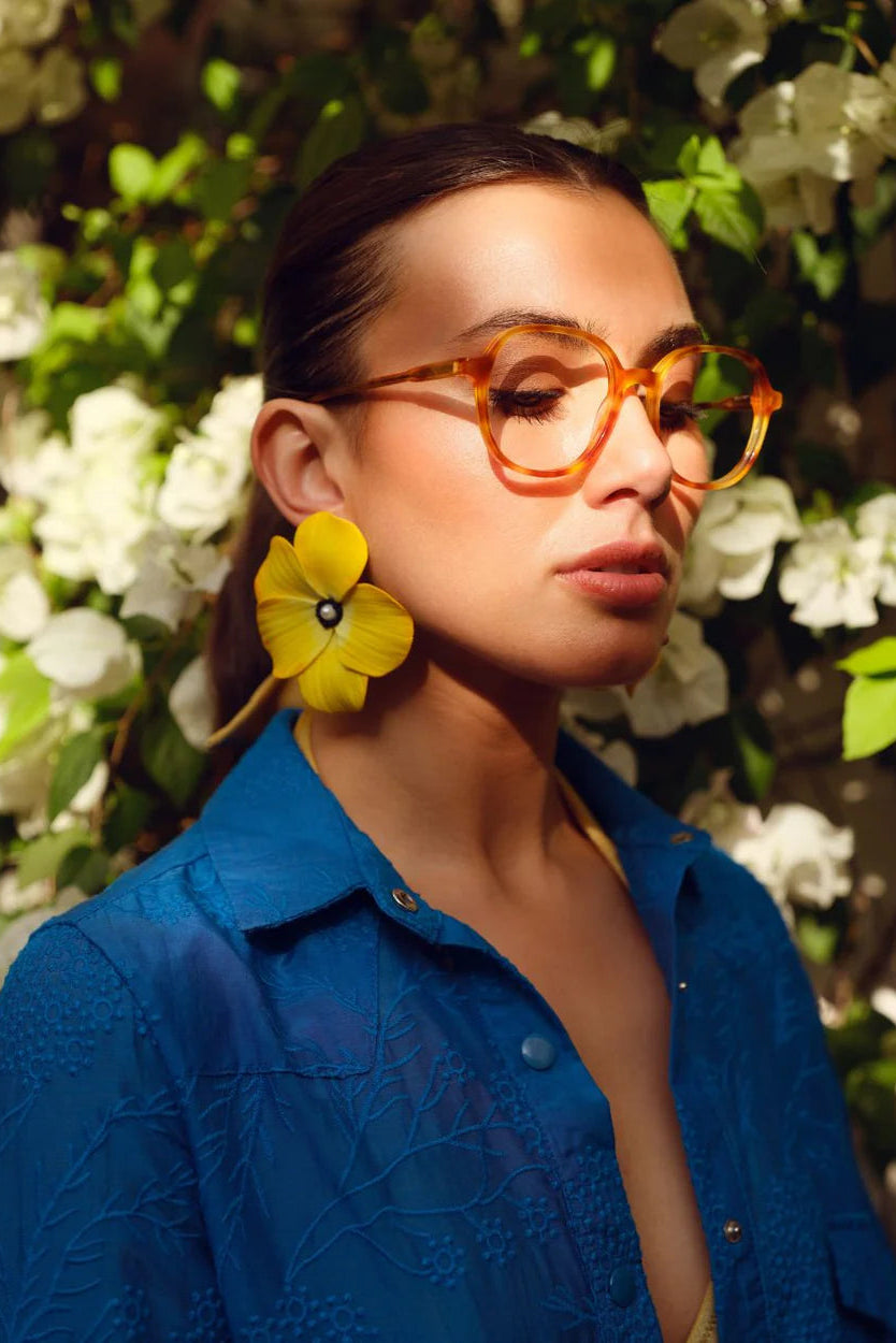 Model wearing oversized Sunshine Earrings featuring handcrafted yellow floral blooms with soft white centers.