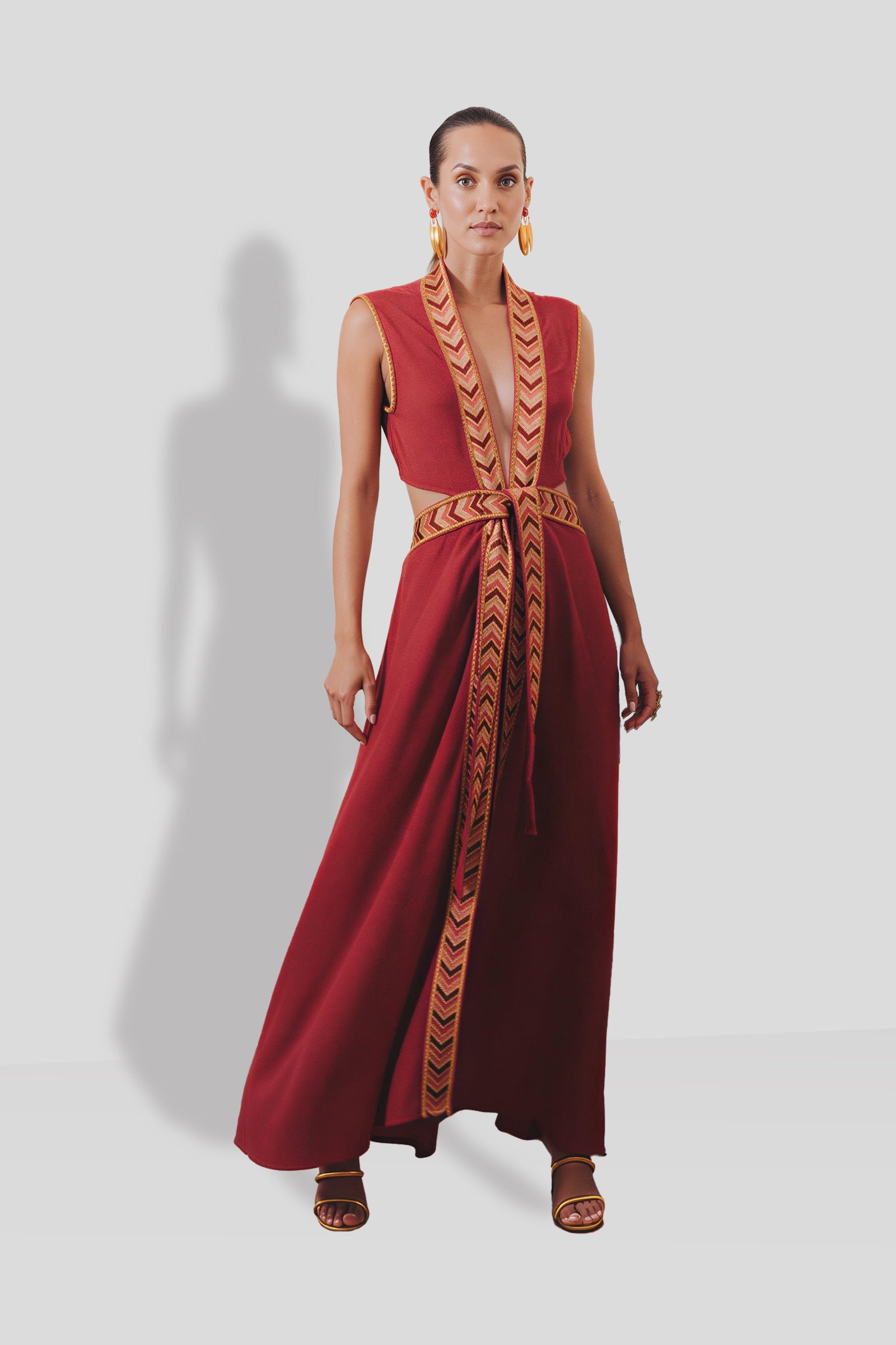 Natacha & Vanessa The Thalie dress in red with a deep V-neck, woven embroidered trim, and detachable braided belt.