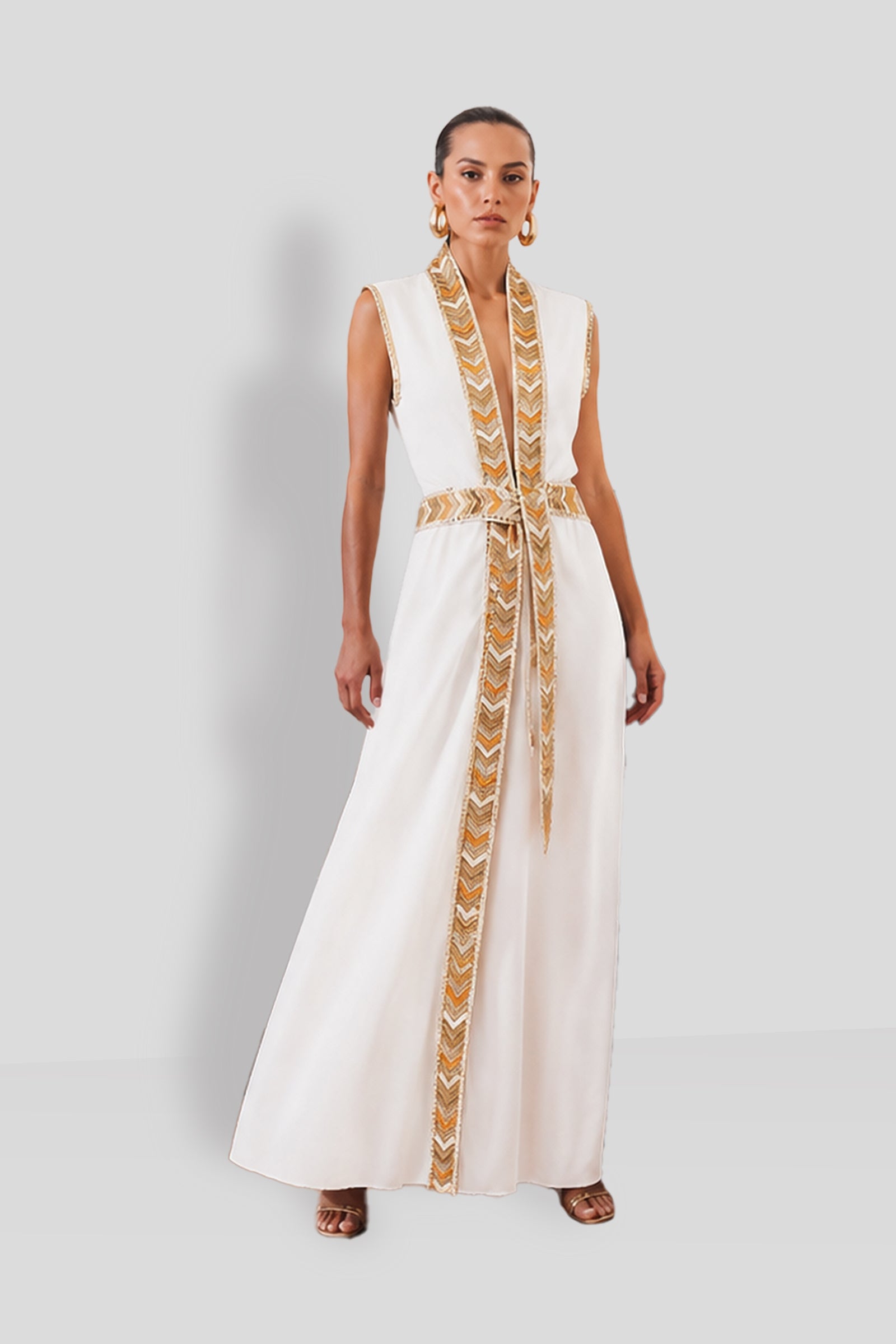 Natacha & Vanessa The Thalie Dress in White with a deep V-neck, woven gold trim, and detachable braided belt.