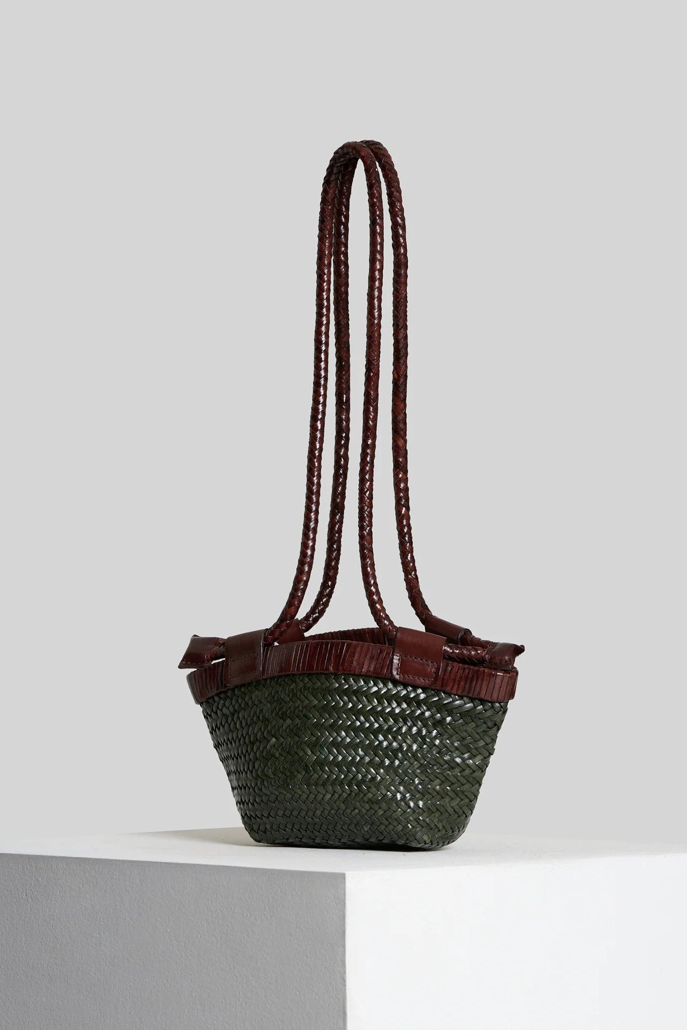 Side-angle view of the Vipera Gauguin Moss-Chocolate handwoven leather bag with extended braided handles.