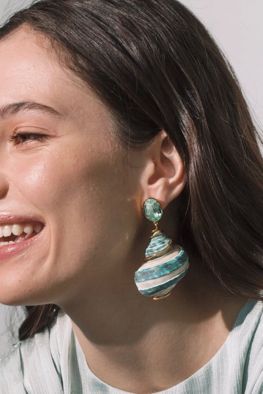 Side view of model wearing Jennifer Behr Wave Earrings with natural green spiral shell drop earrings